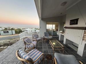a patio with chairs and a fireplace on a house at Restio in Agulhas