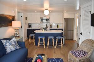 a living room with a blue couch and a kitchen at Stars And Stripes in Kennebunkport