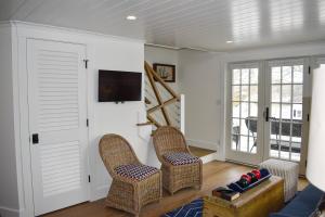 a living room with two chairs and a tv at Stars And Stripes in Kennebunkport