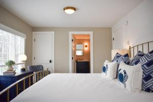 a bedroom with a large bed with blue and white pillows at Stars And Stripes in Kennebunkport +9 photos