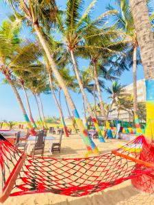 a hammock on a beach with palm trees at Sunset Point Beachfront Villa & Restaurant in Negombo