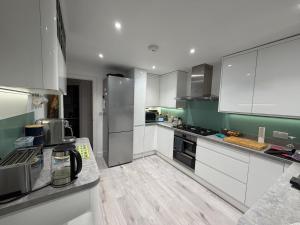 a kitchen with white appliances and green walls at Chez Ana in Saxmundham