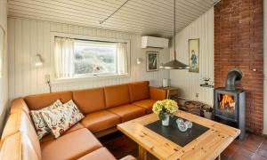 a living room with a couch and a wood stove at VE465-Vejers-Strand-Violvej-1A in Vejers Strand
