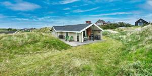 a house on top of a grassy hill at VE465-Vejers-Strand-Violvej-1A in Vejers Strand