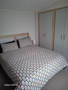 a bedroom with a bed with a wooden headboard at Lewis Sands PC114 in Lossiemouth