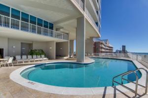 a large pool in a building with chairs and tables at Palazzo 1304 in Panama City Beach