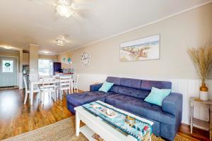 a living room with a blue couch and a table at Maxs Nautical Nook Village OBX in Kitty Hawk