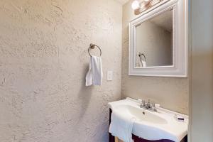 a bathroom with a sink and a mirror at Maxs Nautical Nook Village OBX in Kitty Hawk +9 photos