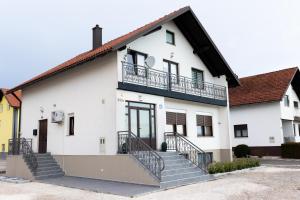 a white building with stairs in front of it at Apartman Orhideja in Gospić