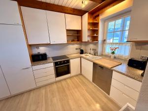 a kitchen with white cabinets and a counter top at Ferienhaus Schlummerkoje in Friedrichskoog