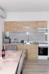 a kitchen with a table and a stove and a sink at Apartman Orhideja in Gospić