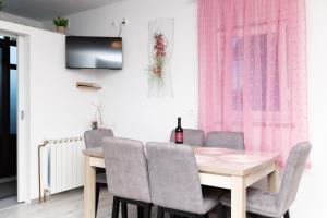 a dining room with a wooden table and chairs at Apartman Orhideja in Gospić