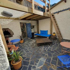 an outdoor patio with blue chairs and tables and a staircase at Gîte à Florac "Les Rêves Bleus" in La Salle-Prunet