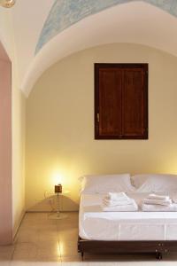a bedroom with a white bed with a wooden cabinet at Blu Rooms in Galatina