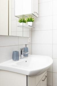 a bathroom with a sink and a mirror at Apartman Orhideja in Gospić +14 photos