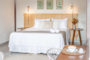 a bedroom with a white bed with a wooden headboard at Casas Gengibre in Alto Paraíso de Goiás