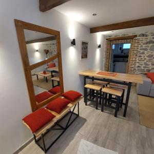 a dining room with a mirror and a table and chairs at La petite Maison in Fromelennes