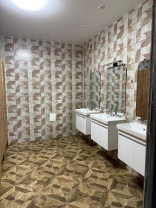 a bathroom with two sinks and two mirrors at Хостел San in Kamianske