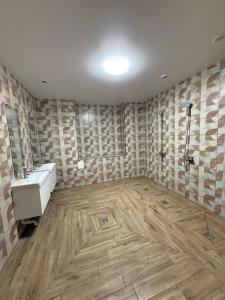 a bathroom with a white sink and a wooden floor at Хостел San in Kamianske