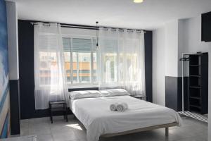 a bedroom with a bed with two towels on it at SolRoom (plz. La Nogalera) in Torremolinos