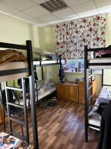 a room with three bunk beds and a desk at Хостел San in Kamianske