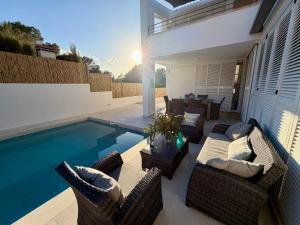 a patio with chairs and a swimming pool at Villa BEACH&OCEAN in Son Serra de Marina