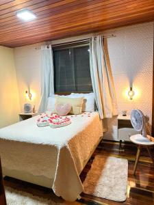 a bedroom with a bed with two towels on it at Chale Allegra - Hidro Aquecida - Vista para o Lago in Venda Nova do Imigrante