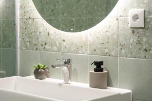 a bathroom sink with a faucet and a mirror at Leiria Boutique Apartment in Leiria +18 photos