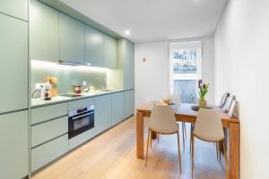 a kitchen with blue cabinets and a wooden table and chairs at Leiria Boutique Apartment in Leiria