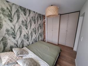 a bedroom with a bed and a wall at Apartament TARNÓW LWOWSKA CENTRUM in Tarnów