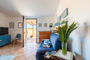 a bedroom with a bed and a vase of flowers on a table at Ri Ale Sa prassa Sardegna Ogliastra in Bari Sardo