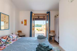 a bedroom with a bed with a blue comforter at Ri Ale Sa prassa Sardegna Ogliastra in Bari Sardo