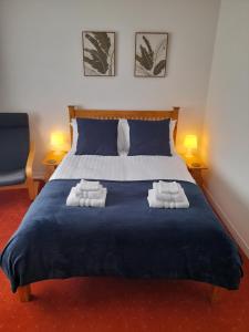 a bedroom with a bed with two towels on it at Greenview in Didcot