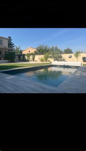 a swimming pool with blue water in a yard at La Villa Carpentrassien in Carpentras