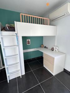 a bedroom with a bunk bed with a desk and a ladder at La Villa Carpentrassien in Carpentras +1 photo