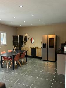 a kitchen with a table and a stainless steel refrigerator at La Villa Carpentrassien in Carpentras