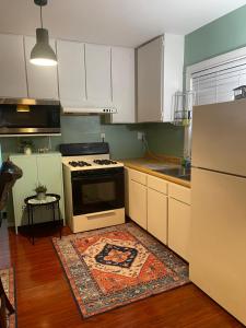a kitchen with white cabinets and a stove and a rug at BACK HOUSE in PASADENA in Pasadena +6 photos