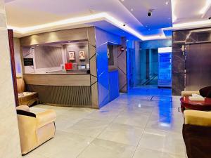 a lobby with a bar and a kitchen with blue lights at Melody Queen Hotel by AURA in Dubai