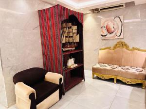 a room with a chair and a shelf with items at Melody Queen Hotel by AURA in Dubai +38 photos