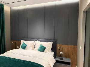 a bedroom with a large bed with green and white pillows at Vila 76 Belvedere in Korçë