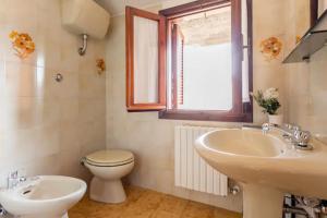 a bathroom with a sink and a toilet and a window at Stanza con terrazzo vista lago LAKEHOLIDAY IT in Castel di Tora +18 photos