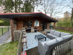 a covered patio with a couch and a table at La Luna in Lanaken