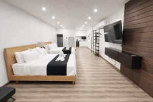 a bedroom with two beds and a flat screen tv at The Hive Boutique Hotel Double Room 109 in Scarborough