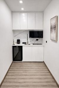 a white kitchen with white cabinets and a sink at The Hive Boutique Hotel Double Room 109 in Scarborough