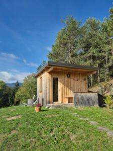 a small wooden cabin in a grassy field at Glamping Gril in Ljubno