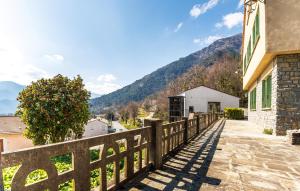 a wooden fence in front of a house with mountains in the background at Juliette in Venaco