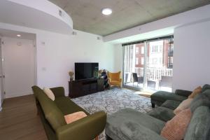 a living room with two couches and a television at Luxurious Midtown Apartment w Sky Lounge & Pool in Atlanta +33 photos