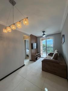 a living room with a couch and a chandelier at Apartamento completo no Planalto in Belo Horizonte