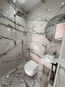 a bathroom with a white toilet and a sink at Luxury Room's by Lika in Sarandë