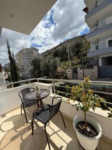 a balcony with two chairs and a table and a plant at Luxury Room's by Lika in Sarandë
